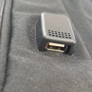 Черна раница със слънчев панел, USB порт и кабел.