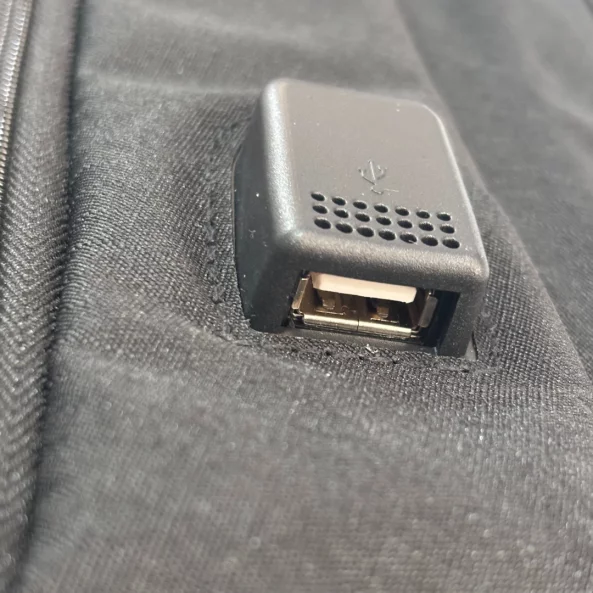 Черна раница със слънчев панел, USB порт и кабел.